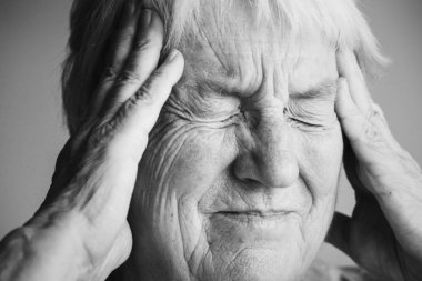 Elderly woman suffering from migraine clipart