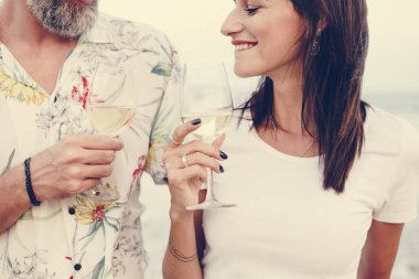 Kumsalda şarap içen çift.