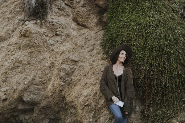 Een Vrouw Met Koptelefoon Door Een Grote Rots — Stockfoto