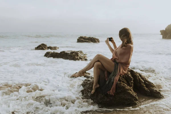 해변에서 그녀의 전화로 사진을 — 스톡 사진