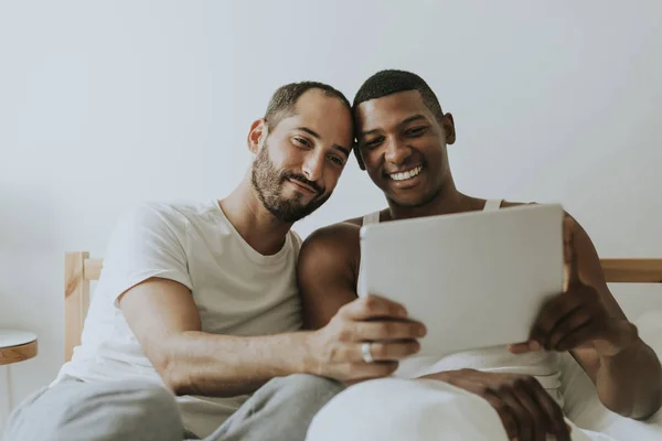 Gay Par Använder Surfplatta Sängen — Stockfoto