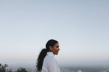 Kadının şehir manzaralı bir tepenin üzerinden