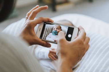 Onun yeni doğan bir fotoğrafını çekmeye anne