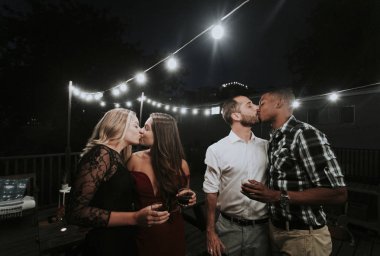 LGBT couples kissing at a party clipart