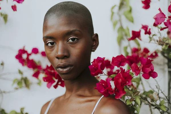 Skinhead Žena Obklopené Červenými Květy — Stock fotografie