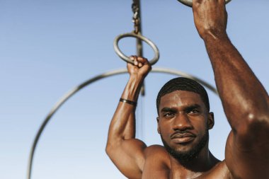 Sahilde çalışan formda bir adam.