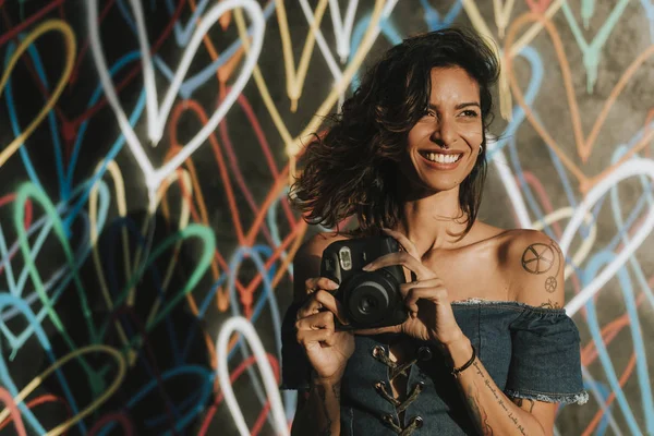 Cheerful woman using an instant camera