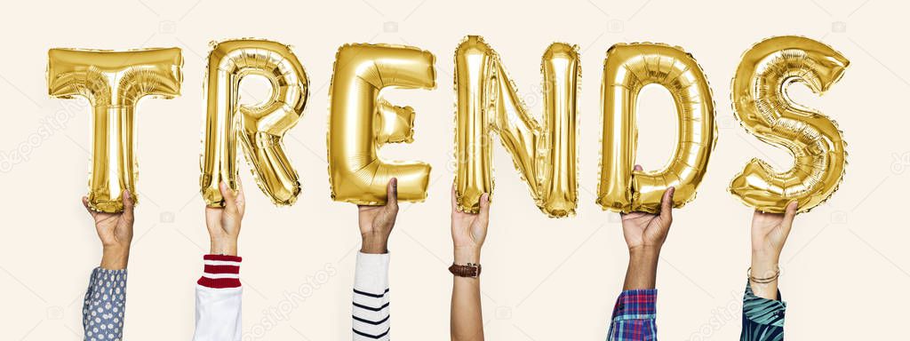 Yellow gold alphabet helium balloons forming the text trends