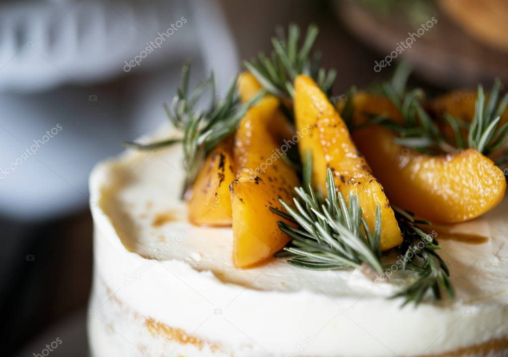 close-up shot of buttercream cake with apricot and rosemary