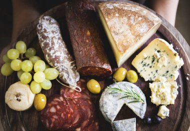 Soğuk etler ve ahşap tahta üzerinde peynir 