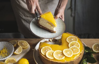Ev yapımı limonlu cheesecake tutan kadın 