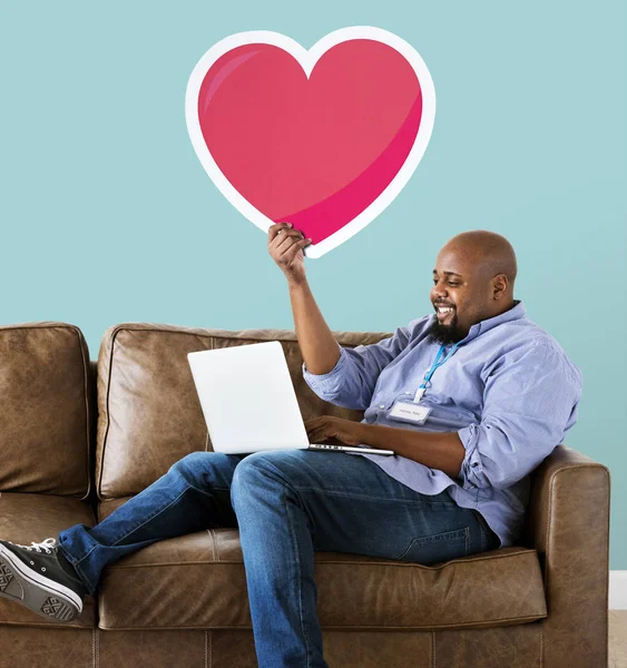 Mann Benutzt Laptop Und Hält Herz Emoticon Und Sitzt Auf — Stockfoto