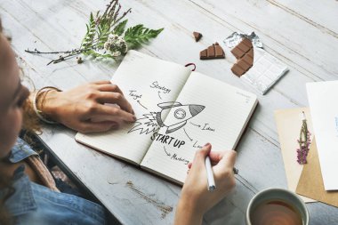 Bir dizüstü bilgisayarda Başlat çizim genç yaratıcı kadın