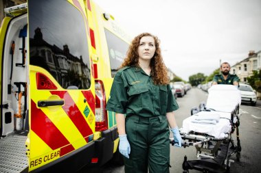 Sağlık görevlileri ambulans sedye haddeleme