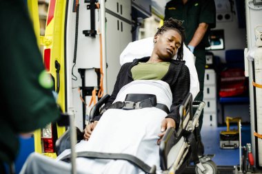 Sağlık görevlileri bir hasta bir ambulansa bir sedyeye taşıma