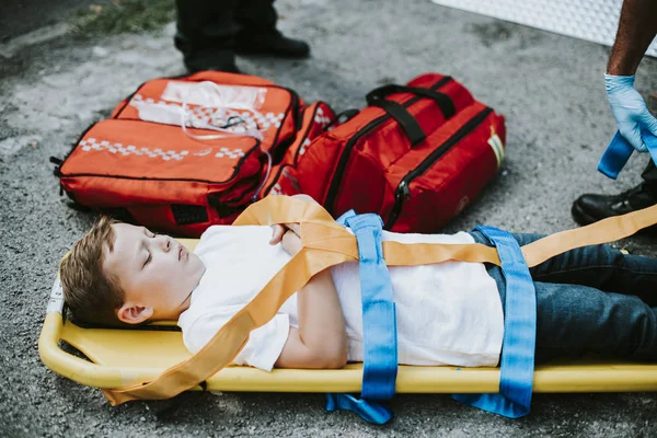 Νέοι Τραυματίες Αγόρι Που Βρίσκεται Ένα Φορείο Ασθενοφόρων — Φωτογραφία Αρχείου