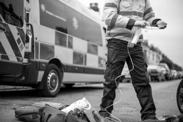 道路で負傷した女性に酸素マスクを準備して男性救急救命士 — ストック写真