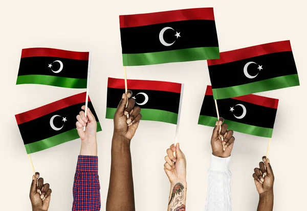 Руки Размахивают Флагами Ливии — стоковое фото