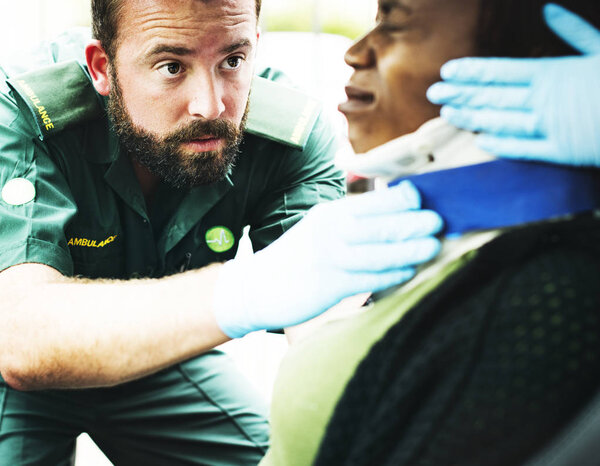 Парамедик надел шейный воротник на раненую женщину из-за автомобильной аварии.
