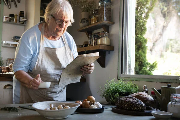 Пожилая Женщина Следует Поваренной Книге Кухне — стоковое фото