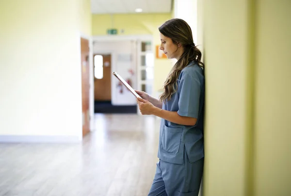 Sjuksköterska Läser Igenom Patientjournaler Korridoren — Stockfoto