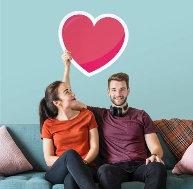 Young couple holding a heart emoticon clipart