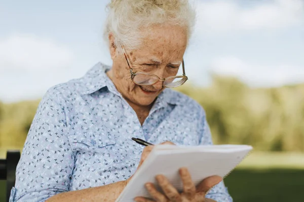 Seniorin Schreibt Ihre Erinnerungen Ein Notizbuch — Stockfoto