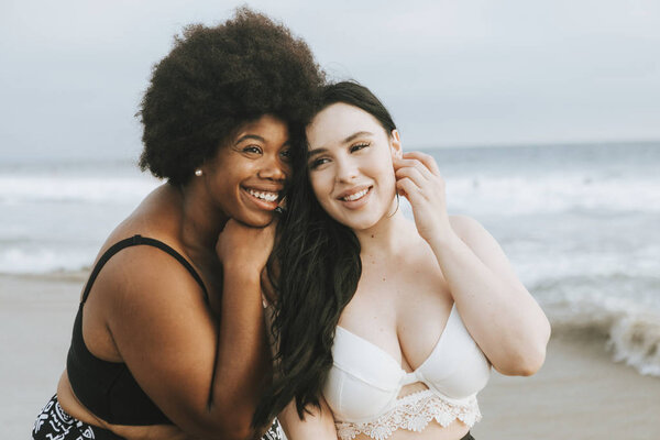 Cheerful beautiful plus size women at the beach