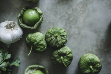 Sarımsak ve yeşil tomatillos gri bir tablo