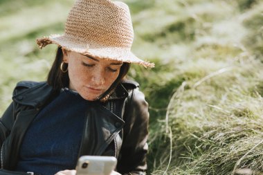 Telefonunu bir parkta kullanan kadın
