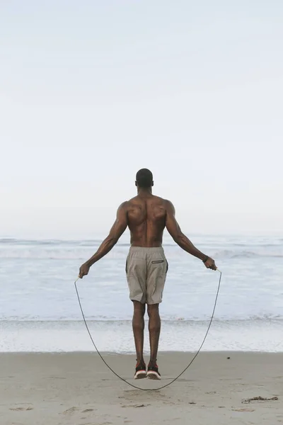Sprawny Człowiek Skacze Przez Skakankę Plaży — Zdjęcie stockowe