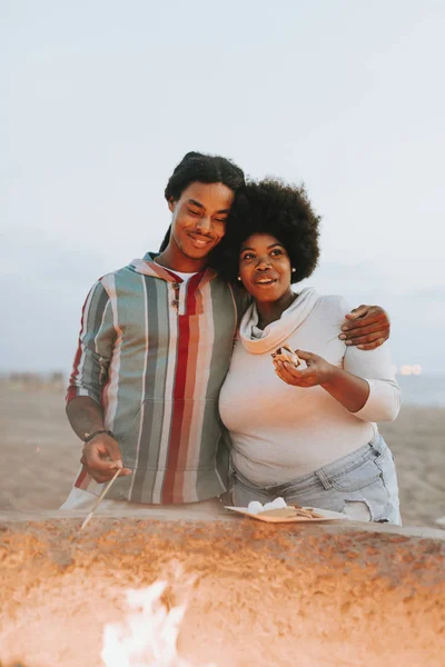 Lovely couple near fire at the beach