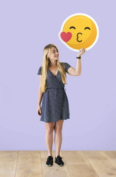 Cheerful Woman Holding Kissing Emoticon — Stock Photo, Image