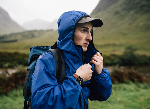 Man zipping up his jacket in the cold
