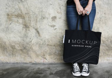 Bir siyah kadın çantası mockup taşıyan kadın