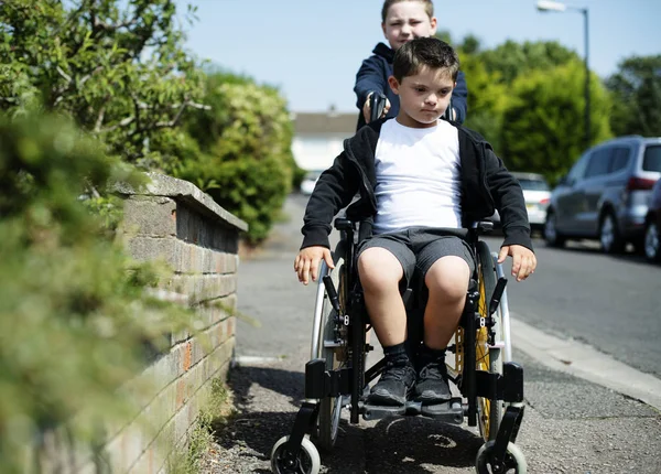 Boy Pushing His Brother Wheelchair — Stock Photo, Image
