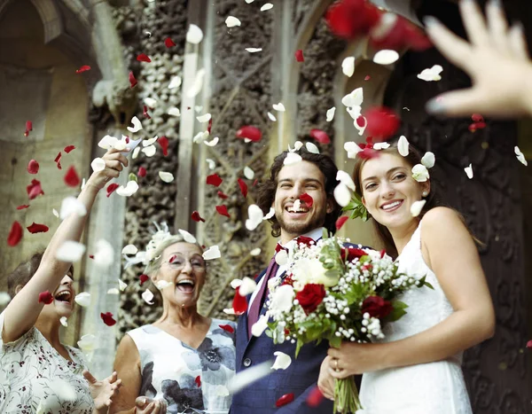 家庭向新婚的新娘和新郎扔玫瑰花瓣 — 图库照片