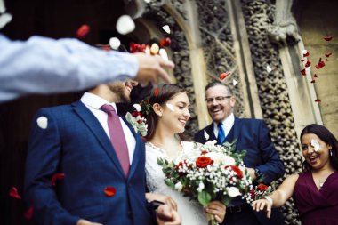Yeni evli gelin ve damat, gül yaprakları atma aile
