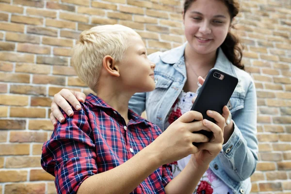 Junge Frau Zeigt Ihrem Bruder Wie Man Ein Smartphone Benutzt — Stockfoto