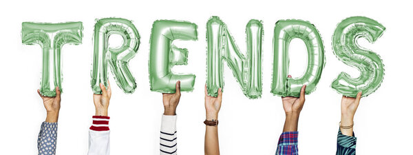 Green alphabet helium balloons forming the text trends