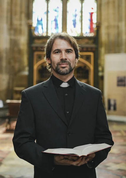 Christian priest standing by the altar