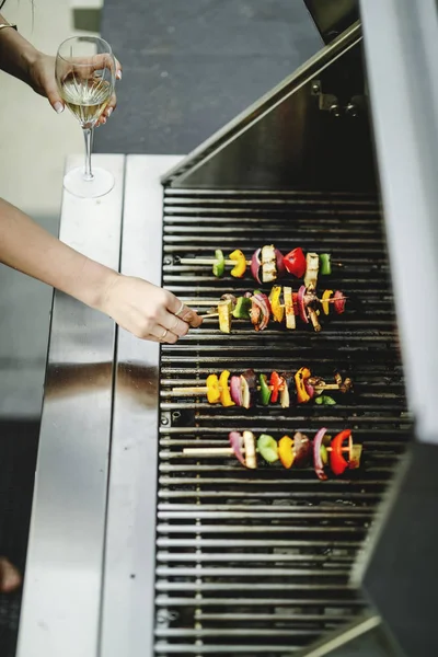 Woman cooking vegan barbecue on a charcoal grill