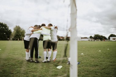 Genç futbolcular strateji futbol sahası üzerinde tartışıyor