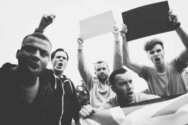 Grup kızgın adam bayrak ve boş panoları bir protesto sırasında bağıran bir İngiltere'de gösterilen
