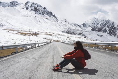 Karakurum karayolu üzerinde oturan genç kadın