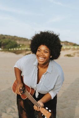 Afro-Amerikan müzisyen ukulele kumsalda oynarken