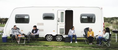 Grup dışında bir karavan parkında oturan insan