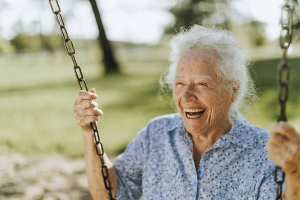 Fröhliche Seniorin Auf Schaukel Auf Spielplatz — Stockfoto