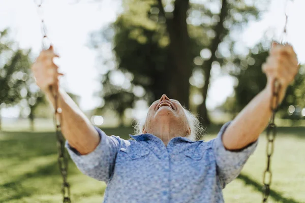 Fröhliche Seniorin Auf Schaukel Auf Spielplatz — Stockfoto