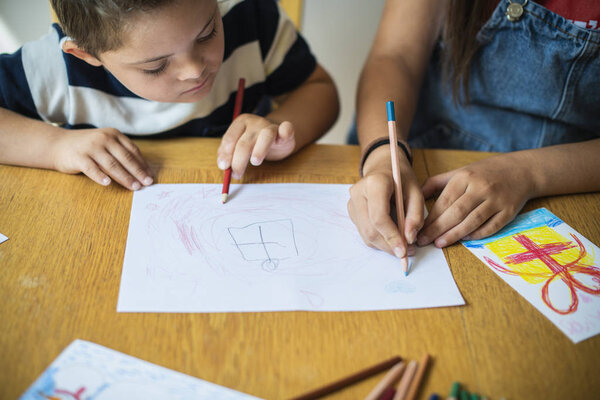 Sister and brother drawing at a table